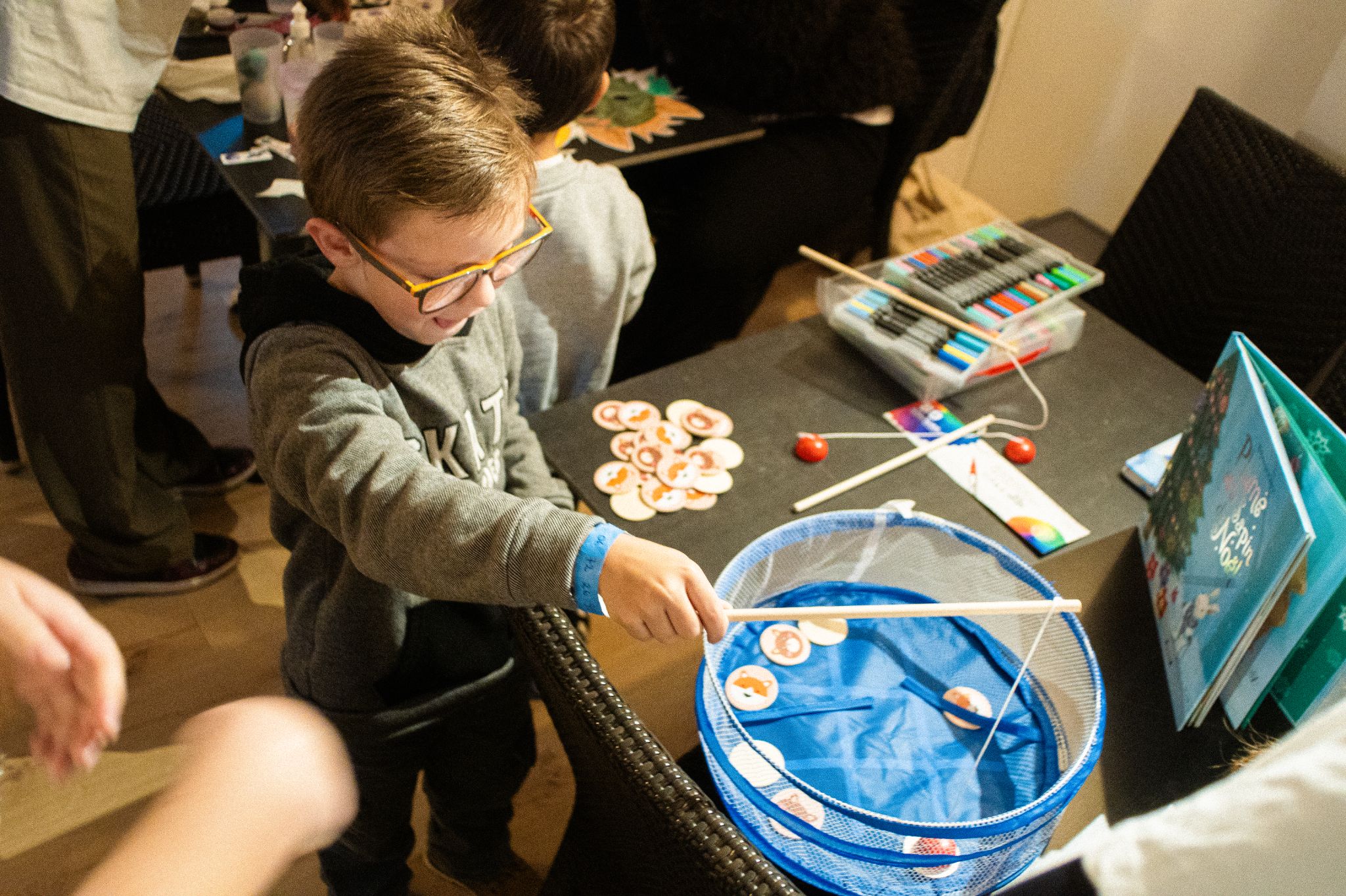 Jeune garçon participant à une animation de pêche à la ligne lors d'un Family Day en entreprise.