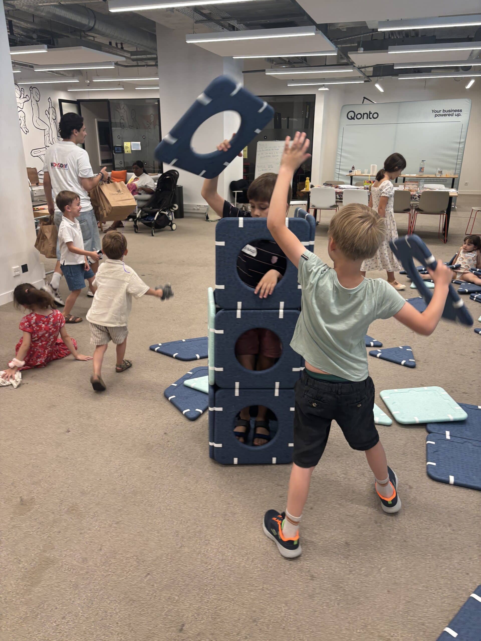 Enfant construisant une cabane pendant une journée d'accueil organisée dans les locaux de son entreprise