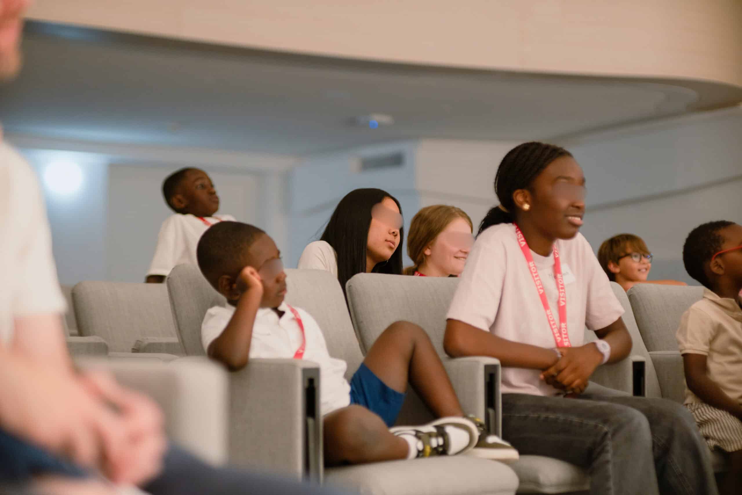 Enfants des salariés installés dans l'auditorium de l'entreprise avant un spectacle