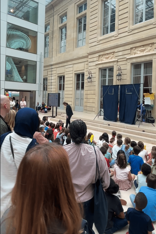 Enfants et parents assis face à la scène pendant la journée des familles AXA