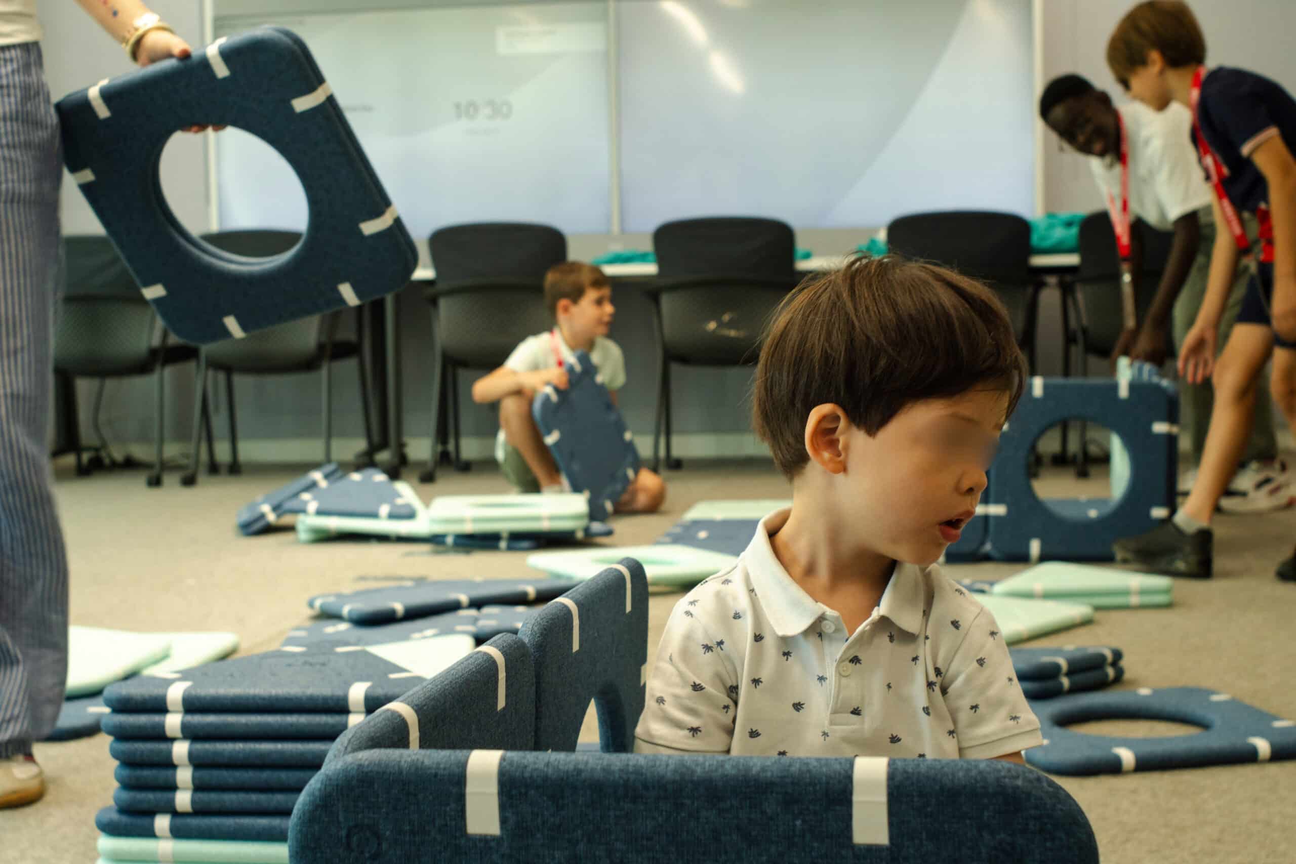 Enfants qui assemblent des modules aimantés pour construire une cabane dans les bureaux de Visa