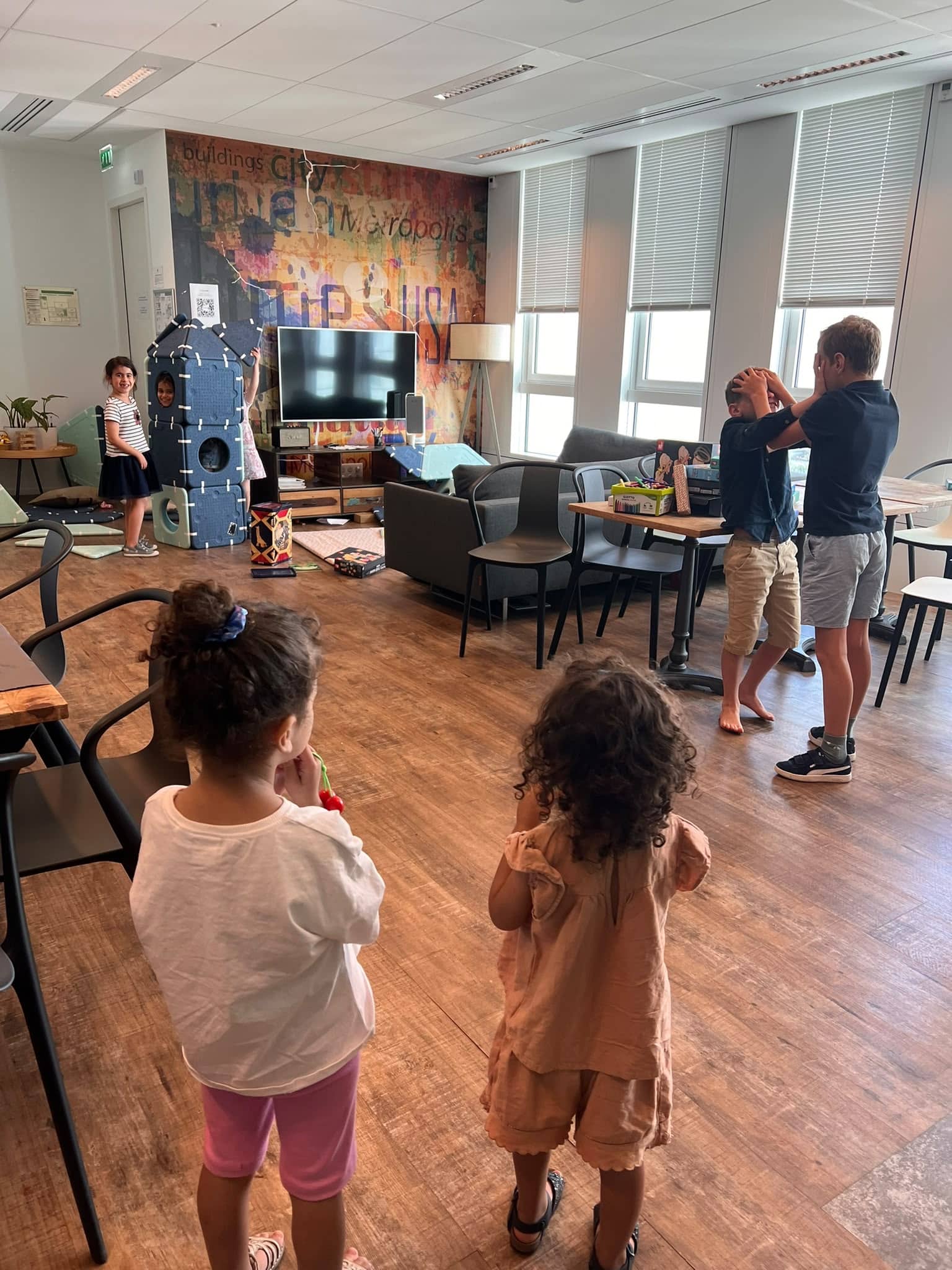 Enfants qui jouent dans l'espace salon des bureaux de LiveRamp pendant la canicule